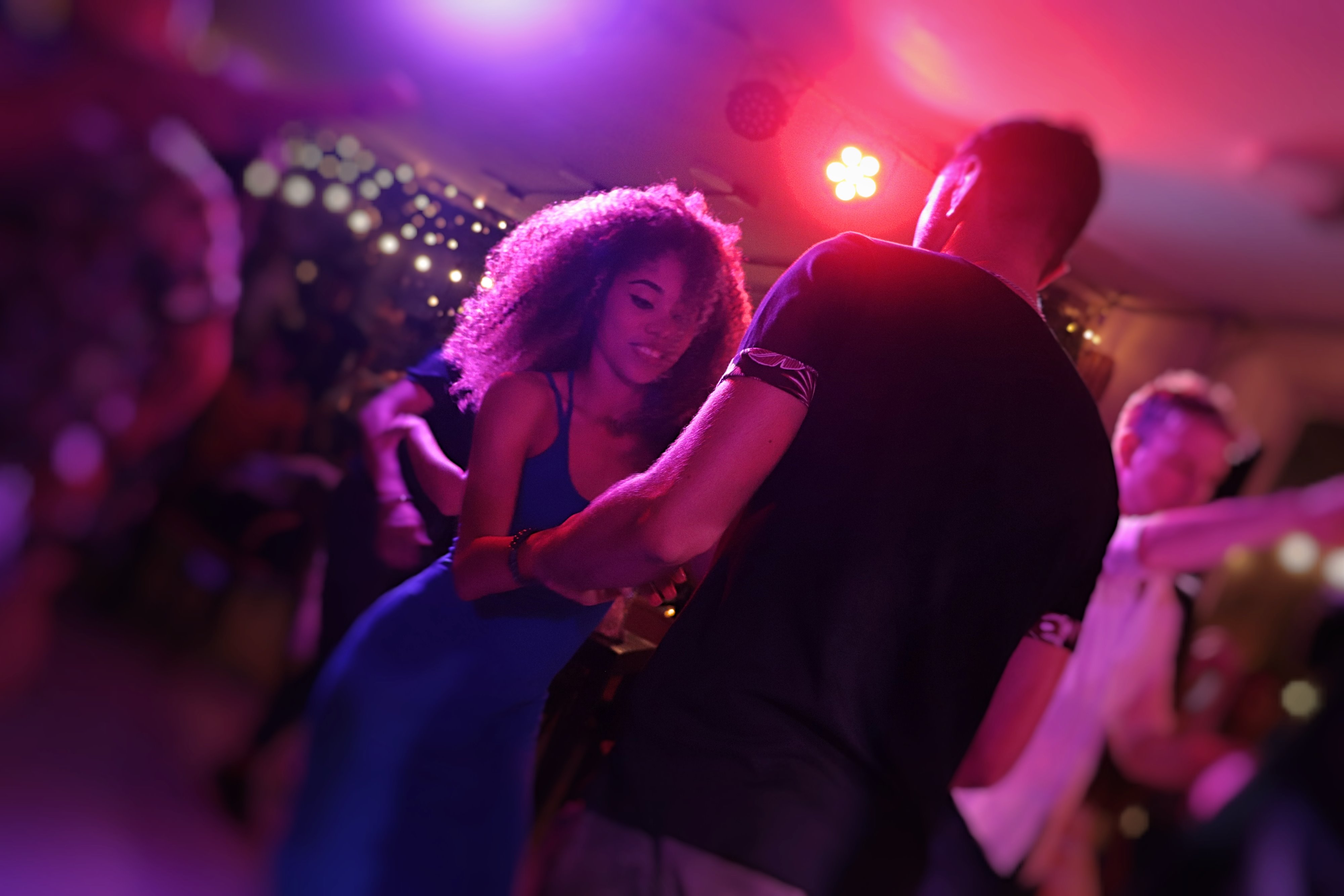 Partners dancing together at a colorful evening Latin dance social